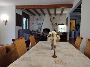a dining room table with a vase of flowers on it at MASIA Del ROC DE SANT CAIETA in Roda de Bará
