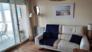 a living room with a white couch with a blue blanket at Vue Panoramique FACE MER in Bray-Dunes