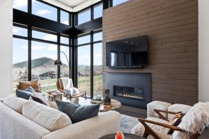 Una sala de estar con un sofá y una chimenea. en Walk to Gondola, Heated Pool, Luxury Interiors, 2 Car Garage, Sleeps 12, Spacious Patio!, en Park City