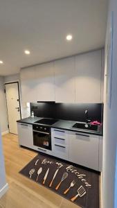 a kitchen with white cabinets and a sink and a rug at Kolonaki Studio in Athens +8 photos
