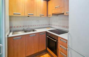 a kitchen with wooden cabinets and a sink at Cozy Apartment In Torrevieja With Wifi in Torrevieja +5 photos