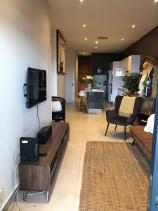 a living room with a couch and a tv at Azure modern beach apartment in La Mercy