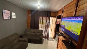 a living room with a couch and a flat screen tv at 900m praia, próximo Beto Carrero in Piçarras