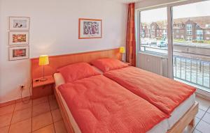 a bedroom with a bed with an orange comforter and a window at Ferienwohnung Ueckermünde in Ueckermünde