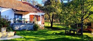 una piccola casa bianca con un portico in un cortile di Kuća u planini T Polje Subjel a Ševrljuge