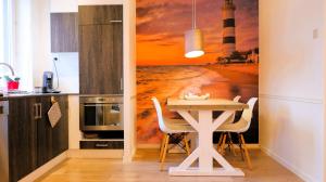 Bonair Gezellig appartement in hartje Wenduine في فينداوني: مطبخ بطاولة جدارية منور