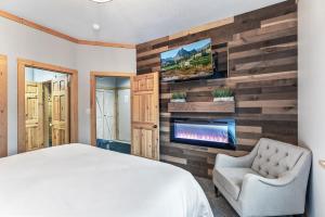 a bedroom with a wood accent wall with a fireplace at Deer Valley Luxury 3 BR, Private Master Suite, Private Hot Tub, Amazing Views in Park City