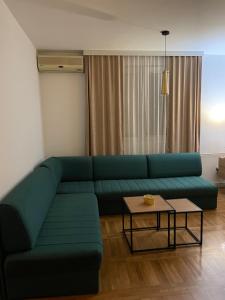 a living room with a green couch and a table at Apartman Raj in Kraljevo