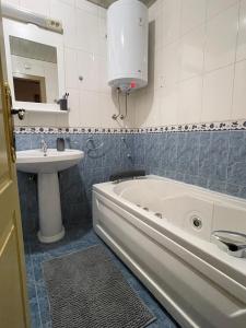 a bathroom with a sink and a bath tub and a sink at Apartman Raj in Kraljevo