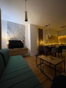 a living room with a couch and a dining room at Apartman Raj in Kraljevo