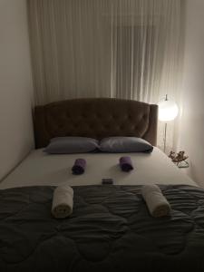a bedroom with a large bed with slippers on it at Apartman Raj in Kraljevo