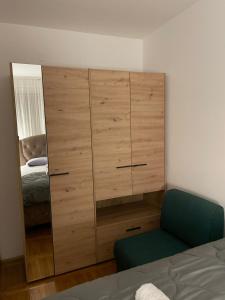 a large wooden cabinet in a bedroom with a bed at Apartman Raj in Kraljevo