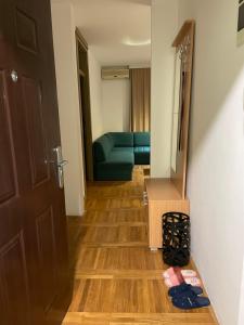 a hallway with a room with a couch and a door at Apartman Raj in Kraljevo
