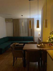 a living room with a couch and a table and a christmas tree at Apartman Raj in Kraljevo
