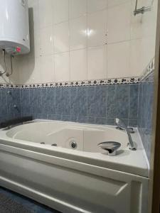 a bath tub with a sink in a bathroom at Apartman Raj in Kraljevo