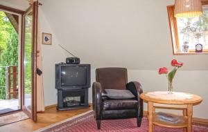 Una sala de estar con una silla y un televisor. en Ferienwohnung Dierhagen, en Neuhaus