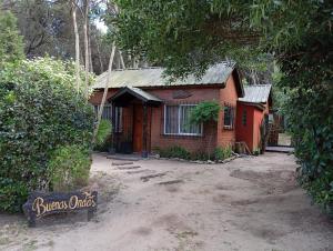 a small brick house with a sign in front of it at Buenas Ondas in Mar Azul