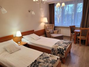 霍伊尼采Hotel Olimp的有两张床和一把椅子的酒店房间