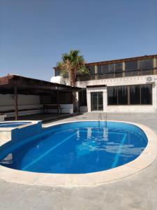 a large blue swimming pool in front of a building at Golden Horse Chalet And Club in Maḩaţţat al Jīzah