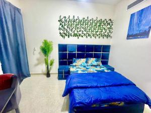 a bedroom with a blue bed in a room at Brand New Studio Near ADCB Metro in Dubai