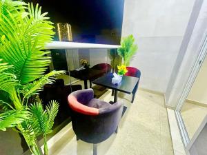 a room with a table and chairs and plants at Brand New Studio Near ADCB Metro in Dubai