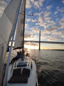 un velero en el agua con un puente en el fondo en Lisboa Sailing Tours - Night on board - Alcantara, en Lisboa