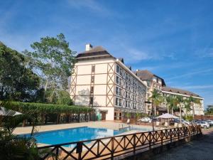 a hotel with a swimming pool in front of a building at Suíte 408 Cond VISTA AZUL in Pedra Azul