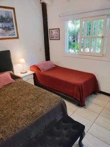 ein Schlafzimmer mit zwei Betten und einem Fenster in der Unterkunft Los Delfines 2 in Mar de las Pampas