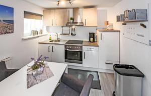 a kitchen with white cabinets and a white table and chairs at Ferienwohnung Graal-Müritz in Graal-Müritz