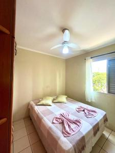 ein Schlafzimmer mit einem Bett mit rosa Handtüchern darauf in der Unterkunft Apartamento Mobiliado em Piracicaba Centro in Piracicaba