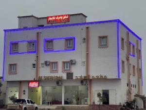 塞拉莱فندق المجد的一座白色建筑，顶部有一块招牌