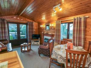 a living room with a table and chairs and a television at Holly Lodge in Saltburn-by-the-Sea