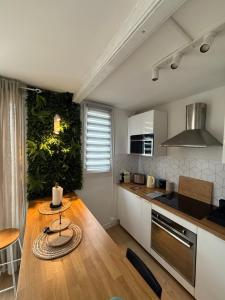 een keuken met een houten tafel en een aanrechtblad bij superbe duplex avec parking gratuit in Grenoble