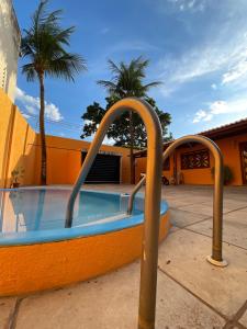 a swimming pool with two metal bars around it at Pousada Conviver-Unidade 1 in Juazeiro do Norte