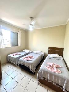 ein Schlafzimmer mit 2 Betten und rosa Handtüchern darauf in der Unterkunft Apartamento Mobiliado em Piracicaba Centro in Piracicaba + 35 Fotos