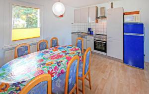 cocina con mesa y nevera azul en Ferienhaus Trassenheide, en Trassenheide