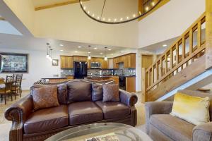 a living room with a couch and a kitchen at Lion Square Lodge East 310A in Vail