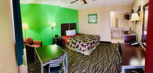 a hotel room with a bed and a green wall at Thunderbird Inn in Liberal