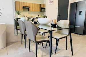 a dining room with a glass table and chairs at Sunset Haven in Midrand +2 photos