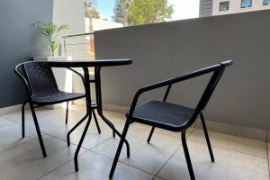 a black table and two chairs on a balcony at Sunset Haven in Midrand