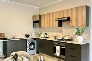 a kitchen with a stove and a washing machine at Sunset Haven in Midrand