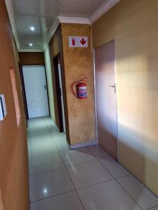 un corridoio con una porta e un cesto appeso al muro di Siba's Place a Ga-Rankuwa