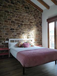 a bed in a room with a brick wall at VillaManuela Vivienda Rural in San Vicente de Toranzo