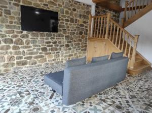 a blue couch in a room with a stone wall at VillaManuela Vivienda Rural in San Vicente de Toranzo