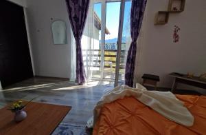 a room with a bed and a large glass door at Pensiunea Glasul Pădurii in Braşov
