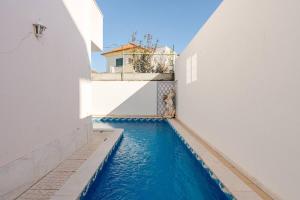 a swimming pool in a building with blue water at Cascais cozy & air conditioning & large in Cascais