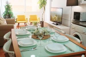 a dining table with plates and wine glasses on it at Apartamento en Roda de Barà in Roda de Bará