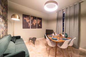 a living room with a table and a green couch at LOGGIA delle MERCANZIE in Brescia