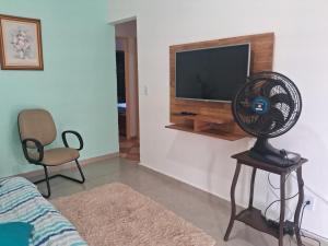 a living room with a fan and a television at Espaço Tranquilo -preço até 04 pessoas in Pôrto Feliz