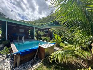 a swimming pool in front of a house at Fare JUANITA HOE in Opoa